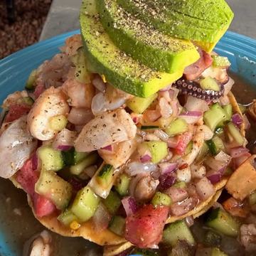 Tostada de mariscos con rebanadas de aguacate