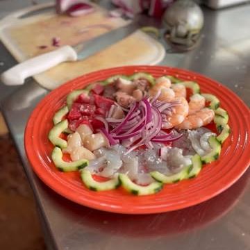 Plato de camarones con pepino y cebolla morada